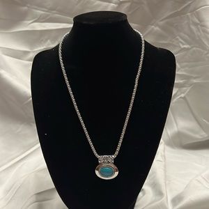 Turquoise and silver pendant necklace.